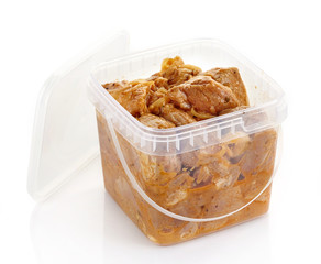 Marinated pork meat pieces in a plastic box