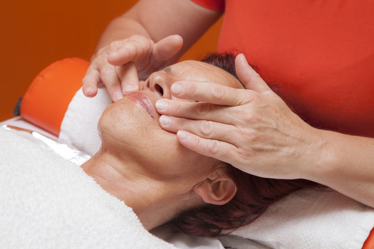 Cute woman gets professional facial massage, lymphatic drainage