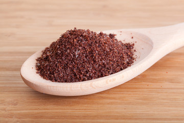 Sumac spice in a wooden spoon on a table
