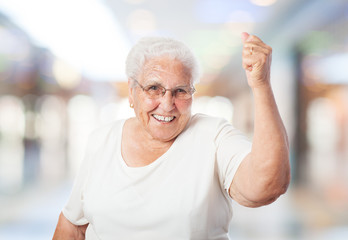 portrait of old woman doing a winner gesture