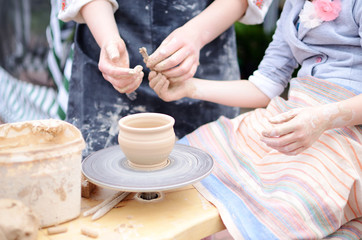Fototapeta na wymiar Hands working on throwing wheel, master class of studio pottery