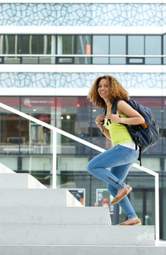 Portrait Of A Female Student Walking Up Stairs To College