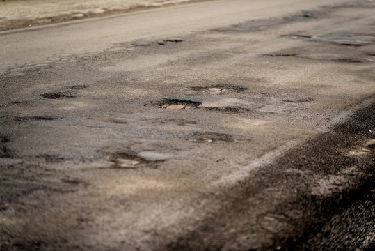 Damaged car road with a lot of cracks