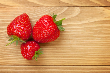 Ripe strawberries over wooden table background