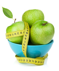 Fresh green apples with yellow measuring tape