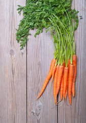 Carrots with tops on wooden boards