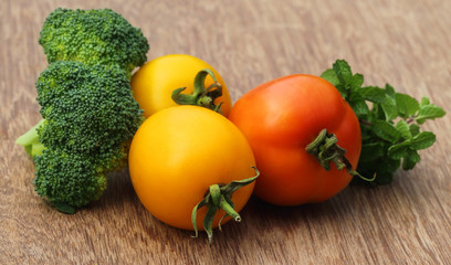 Ripe tomato with mint leaves and broccoli