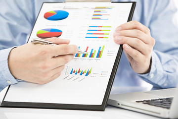 Businessman analyzing investment charts with laptop