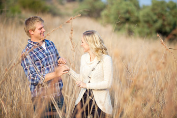 Young couple playing in tall grass