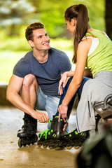 Young couple preparing for rollerblades