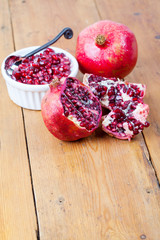 Fresh pomegranate fruit and pips in white bowl