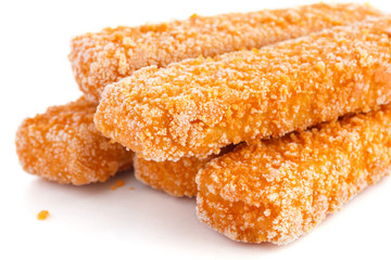 Frozen bread crumbed fish fingers on white