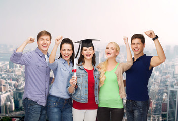 Obraz premium group of standing smiling students with diploma