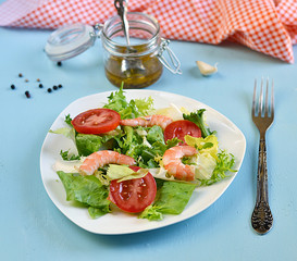 Salad with tomato, king shrimps and sauce vinaigrette