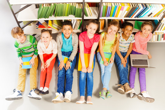 Seven smiling children sitting together on floor