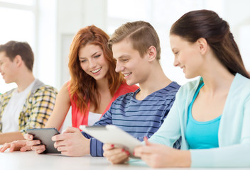 Fototapeta premium smiling students with tablet pc at school