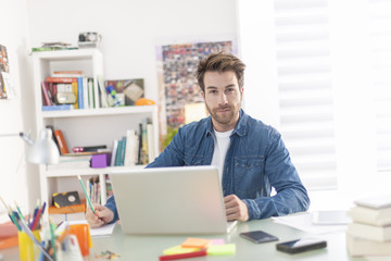 Fototapeta na wymiar young man working on a laptop indoors