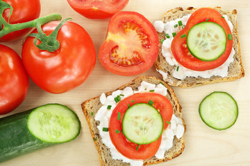 Sandwich with cottage cheese, tomato and cucumber on wood backgr