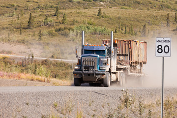 Industrial truck driving dusty rural dirt road