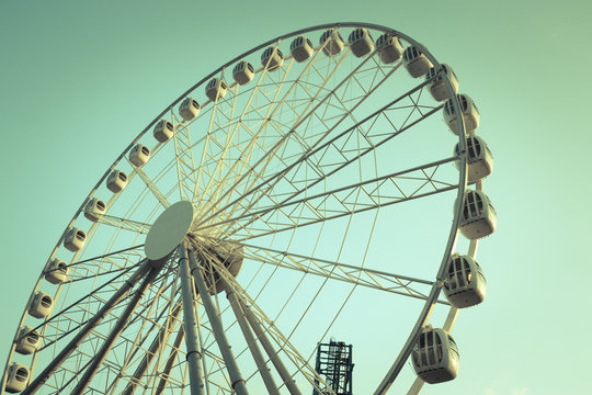 Retro style image of a ferris wheel against blue sky