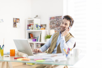 young architect at phone working at office