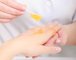 Beautician applying cream on client hands. Beauty salon