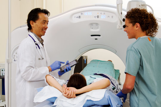 Doctor and technician with patient for CAT scan