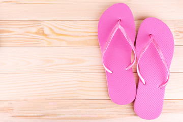 Bright flip-flops on wooden background