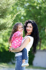 Happy mom and daughter. Walk in the green park