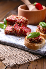 Composition with knife,  tasty sandwiches with salami sausage,