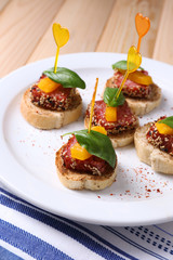 Tasty canapes with salami, pepper  and basil leaves,