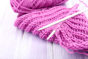 Knitting with spokes on wooden background