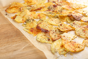 Homemade potato chips on wooden table