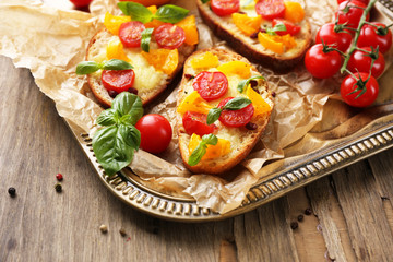 Tasty bruschetta with tomatoes, on old wooden table