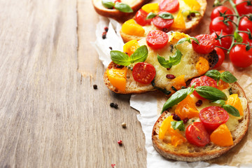 Tasty bruschetta with tomatoes, on old wooden table