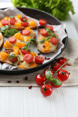 Tasty bruschetta with tomatoes in pan, on table