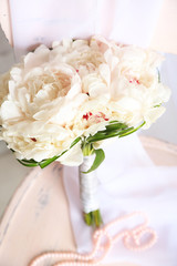 Beautiful wedding bouquet on   wooden chair on light background