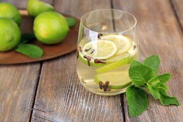 Fresh summer drink with lime and cloves in glass,