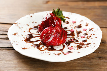 Red ripe strawberries with chocolate on wooden table