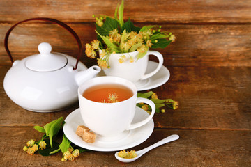 Tasty herbal tea with linden flowers on wooden table