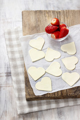 Making puff pastry cookies in heart shape filled with strawberri