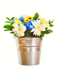 Bouquet of bright flowers in a bucket isolated over white backgr