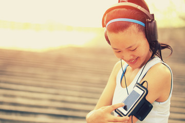 woman unner listening to music in headphones from smart phone