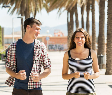 Smiling young couple running outdoor