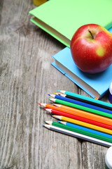 Books, pencils and an apple