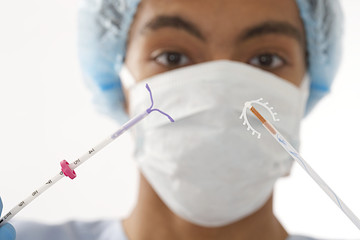 Young doctor holding two type of  IUD birth control