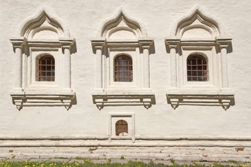 White brick wall with three  arched window.