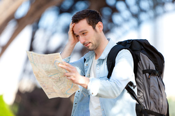 Young attractive tourist reading map in Paris