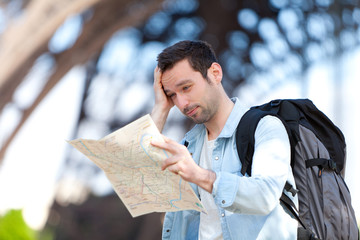 Young attractive tourist reading map in Paris