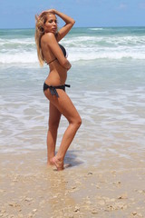 Fototapeta na wymiar Beautiful woman with a bikini posing sexy at the beach